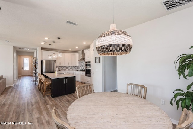 dining space with wood-type flooring and sink