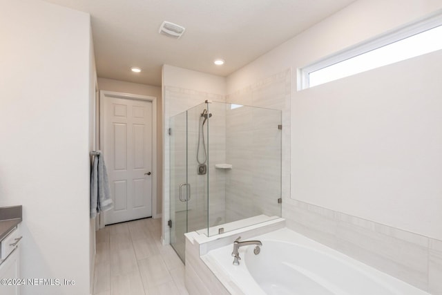 bathroom featuring vanity and shower with separate bathtub