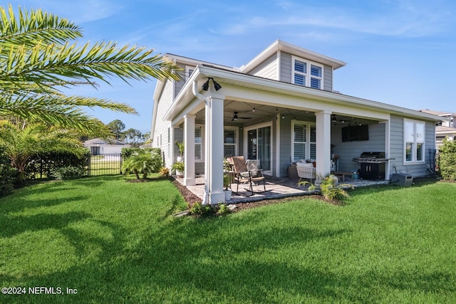 back of property with a lawn, a patio area, and ceiling fan