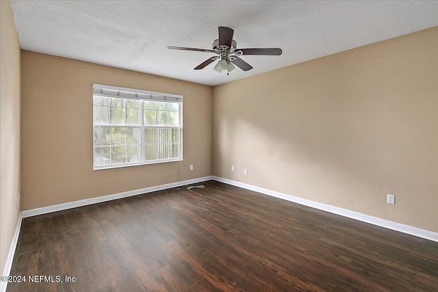 empty room with ceiling fan, dark wood-type flooring, and a textured ceiling