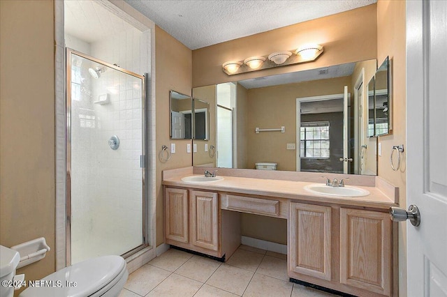 bathroom featuring tile patterned floors, a textured ceiling, toilet, vanity, and a shower with shower door