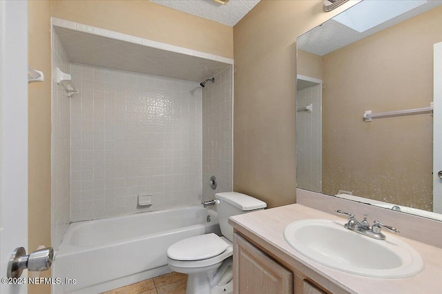 full bathroom featuring vanity, tile patterned floors, tiled shower / bath, a skylight, and toilet