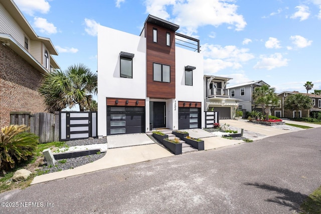 1304 Strand St, Neptune Beach, FL 32266 - contemporary home with stucco siding, a garage, a residential view, and concrete driveway