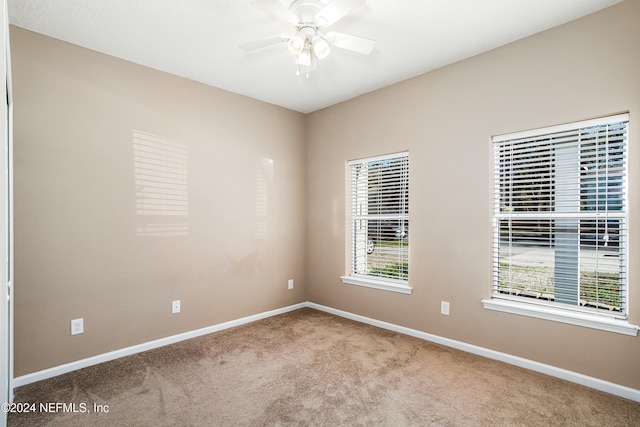 carpeted spare room with ceiling fan