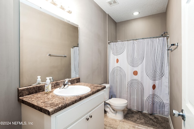 bathroom featuring vanity, a textured ceiling, and toilet