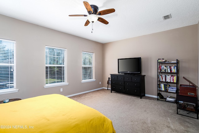 carpeted bedroom with a textured ceiling and ceiling fan