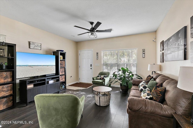 living room with a textured ceiling, dark hardwood / wood-style floors, and ceiling fan