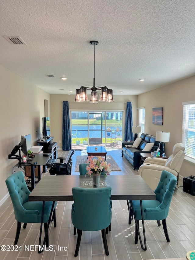 dining area featuring wood-type flooring and a textured ceiling