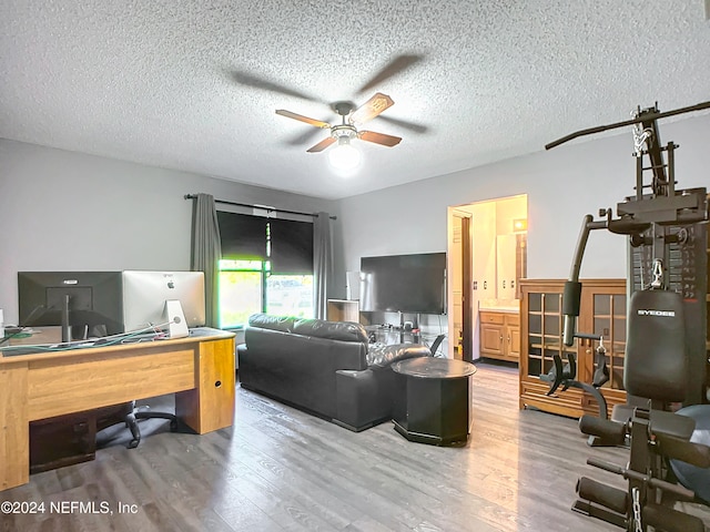 living room featuring a textured ceiling, hardwood / wood-style flooring, and ceiling fan