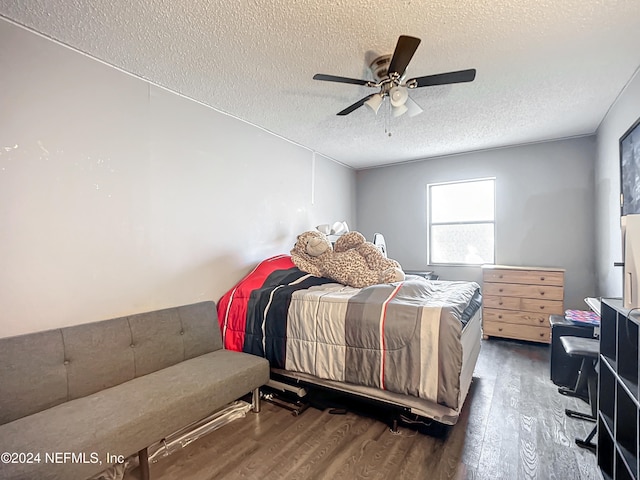 bedroom with a textured ceiling, ceiling fan, and dark wood-type flooring