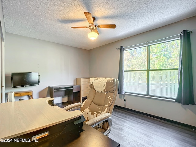 office area with ceiling fan, hardwood / wood-style floors, and a textured ceiling