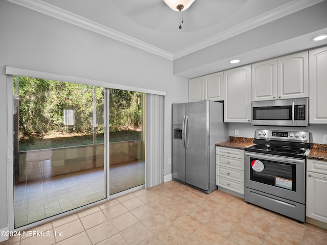 kitchen with white cabinets, dark stone countertops, ornamental molding, and stainless steel appliances