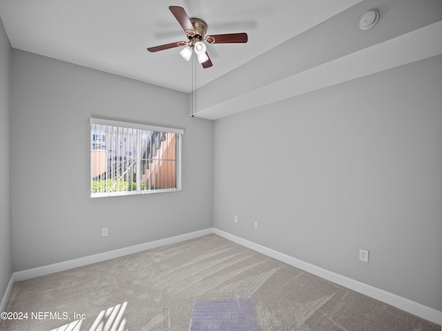 carpeted spare room with ceiling fan