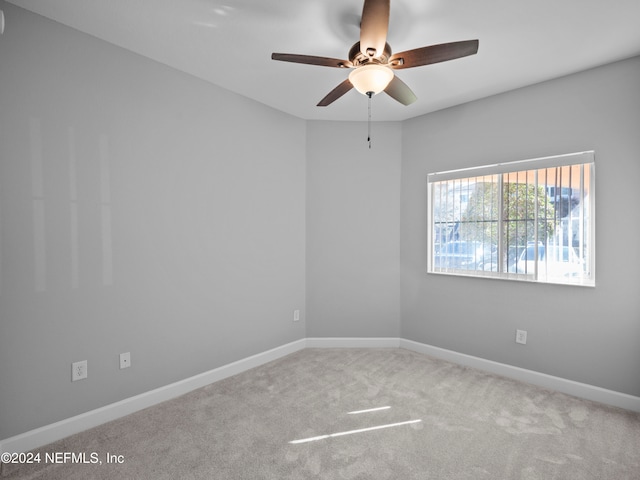 carpeted spare room featuring ceiling fan