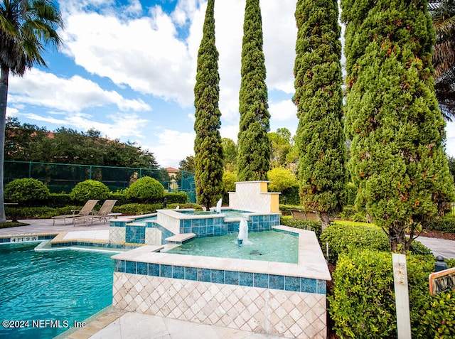 view of swimming pool with a jacuzzi and pool water feature