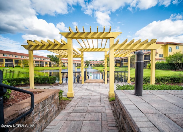 view of patio with a pergola and a water view