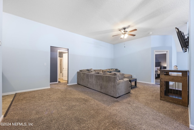 carpeted living room with a textured ceiling and ceiling fan