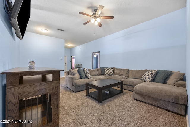 living room featuring carpet flooring, ceiling fan, and a textured ceiling