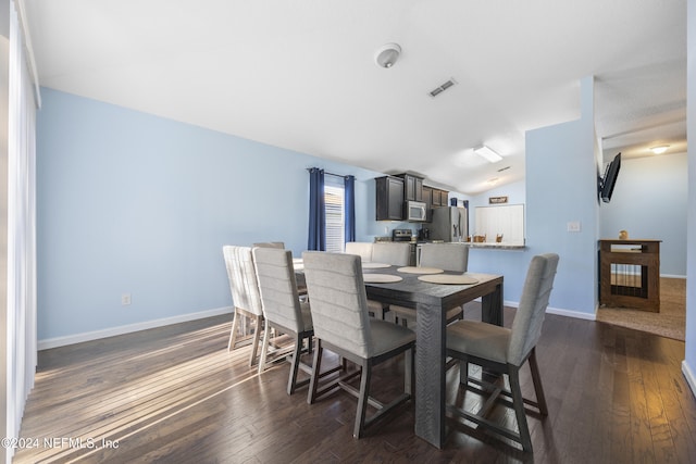 dining room with dark hardwood / wood-style flooring and lofted ceiling