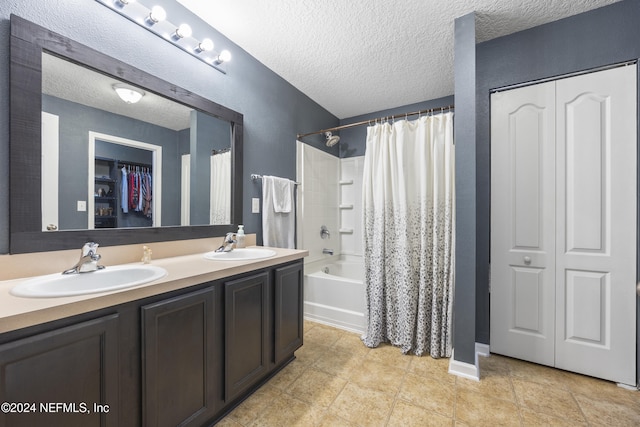 bathroom with vanity, a textured ceiling, and shower / tub combo with curtain