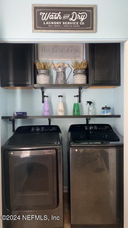 washroom featuring cabinets and washing machine and dryer