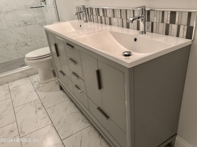 bathroom with vanity, tiled shower, and toilet