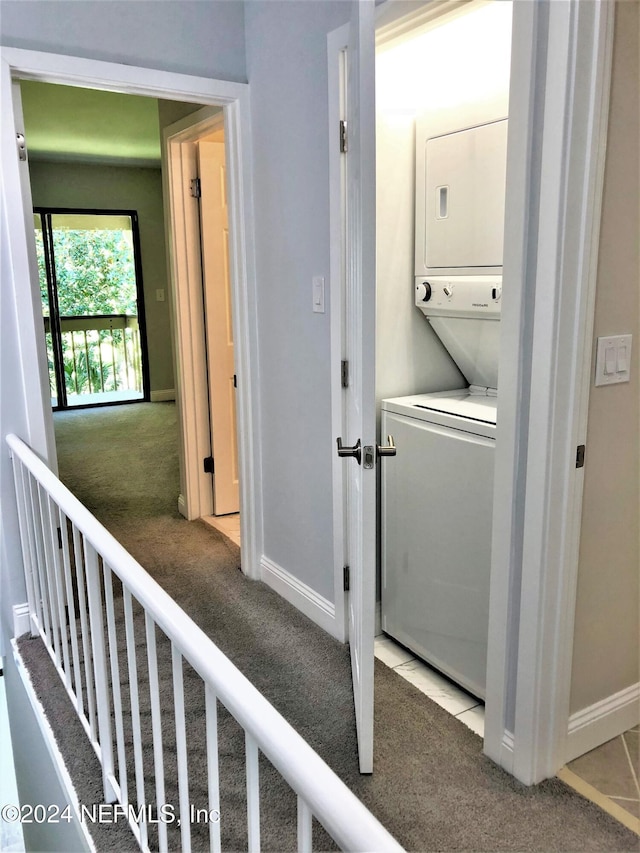 laundry area with stacked washing maching and dryer and light carpet