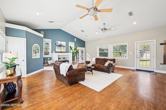 living room featuring hardwood / wood-style flooring, ceiling fan, and lofted ceiling