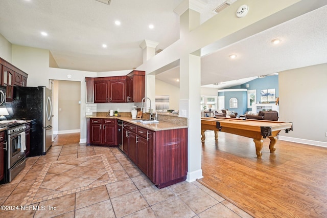 kitchen with stainless steel range, sink, high vaulted ceiling, light hardwood / wood-style floors, and pool table