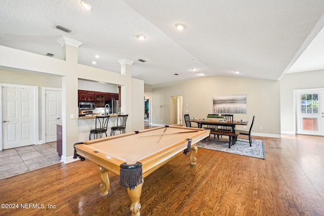 rec room featuring a textured ceiling, sink, light hardwood / wood-style flooring, billiards, and lofted ceiling