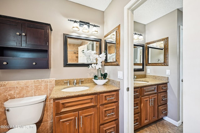 bathroom featuring tile patterned flooring, vanity, a textured ceiling, and toilet