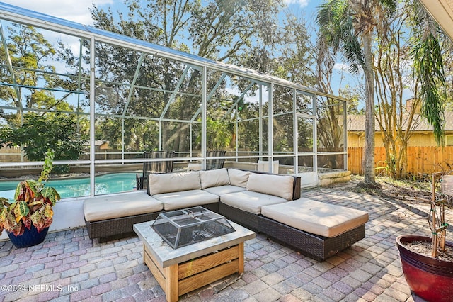 view of patio featuring glass enclosure, a fenced in pool, and an outdoor living space with a fire pit