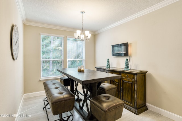 dining area with a chandelier, a textured ceiling, and ornamental molding