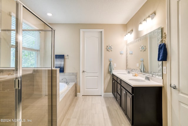 bathroom featuring vanity, a textured ceiling, and shower with separate bathtub