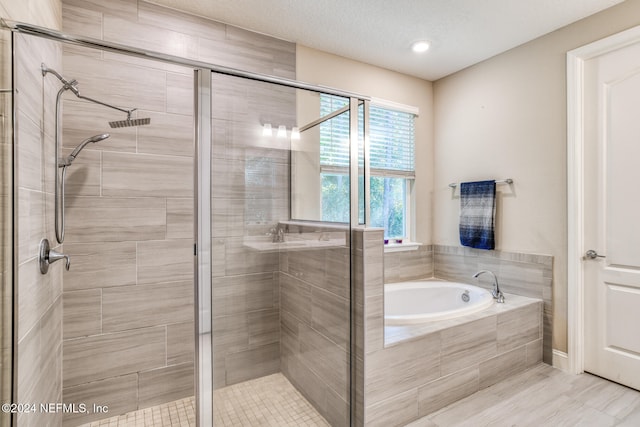 bathroom with plus walk in shower and a textured ceiling