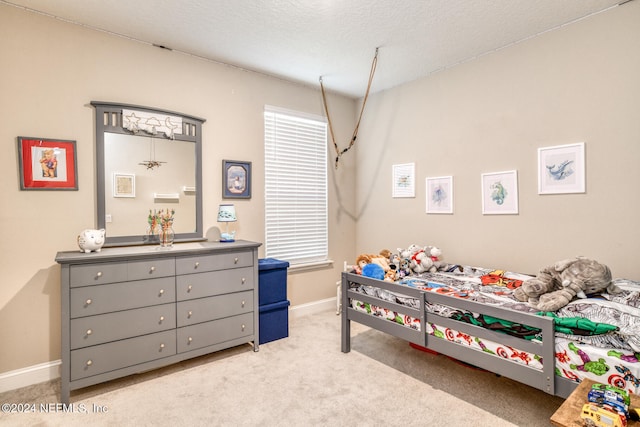 bedroom with a textured ceiling and light colored carpet