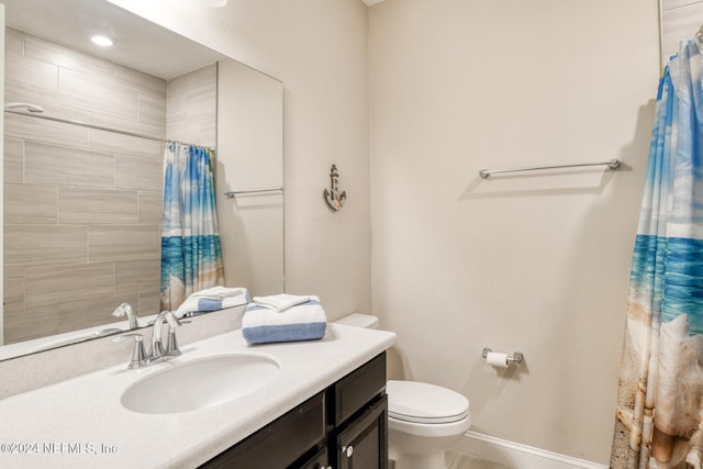 bathroom featuring curtained shower, vanity, and toilet