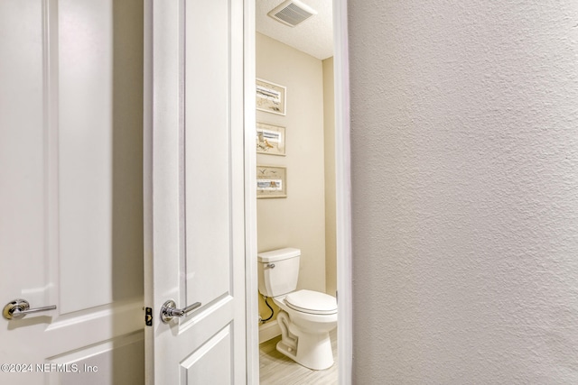 bathroom featuring hardwood / wood-style floors and toilet