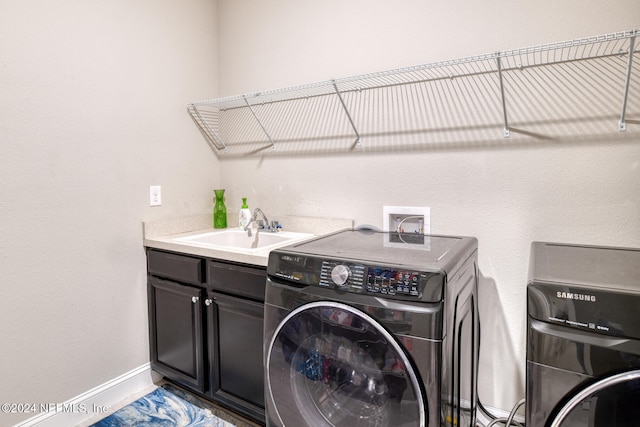 washroom featuring cabinets, independent washer and dryer, and sink