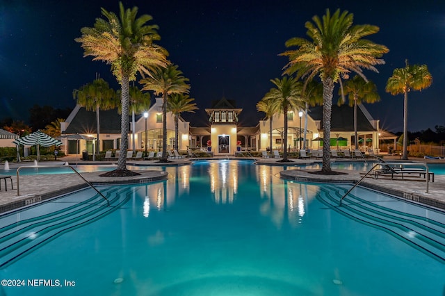 pool at twilight featuring a patio