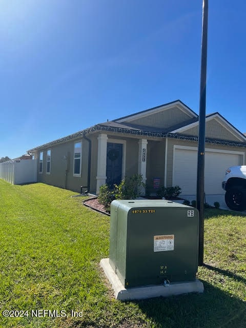 ranch-style home with a garage and a front lawn