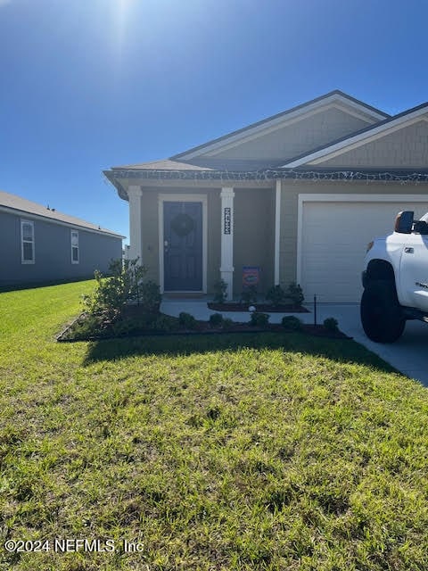 view of front facade with a garage and a front lawn