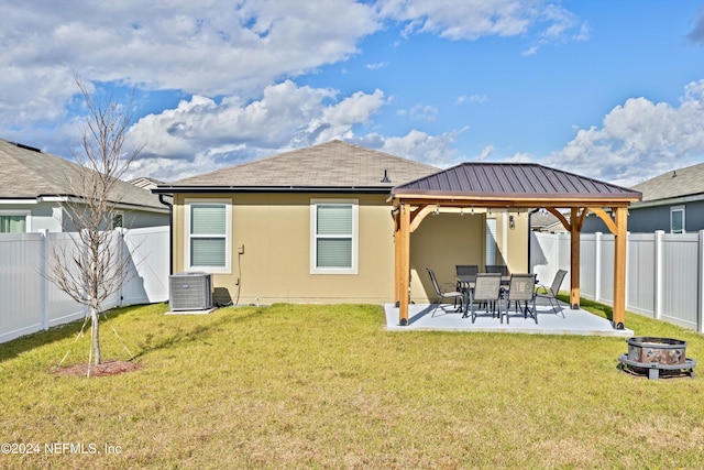 rear view of property with a gazebo, central air condition unit, a lawn, and a patio