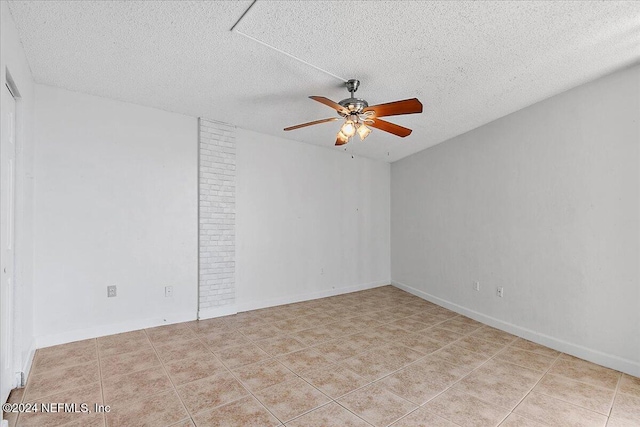 empty room featuring a textured ceiling, ceiling fan, and light tile patterned flooring