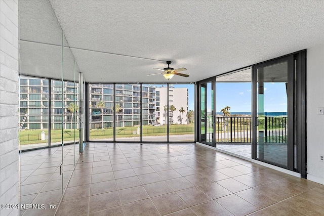 unfurnished sunroom with ceiling fan