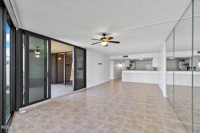 unfurnished living room with ceiling fan, floor to ceiling windows, and a textured ceiling