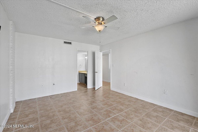 spare room with a textured ceiling and ceiling fan