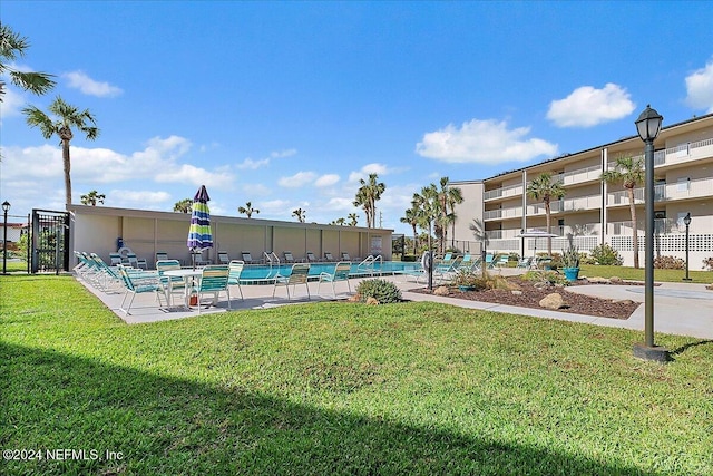 view of home's community featuring a lawn, a patio area, and a pool