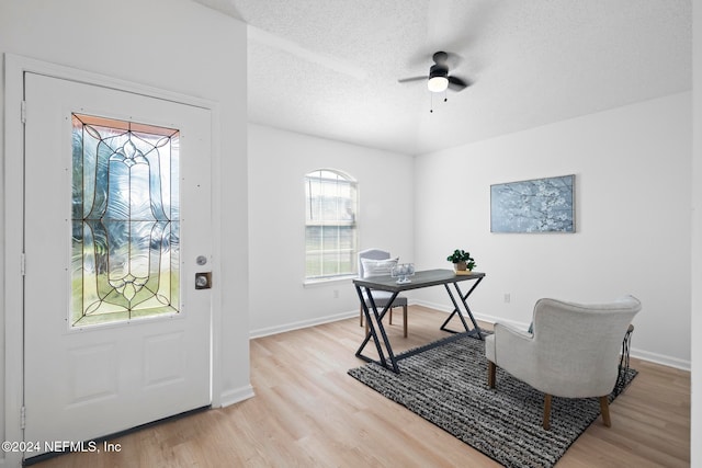 office with ceiling fan, light wood-type flooring, and a textured ceiling