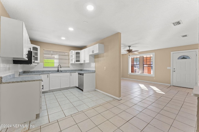 kitchen featuring white cabinets, stainless steel dishwasher, a wealth of natural light, and sink